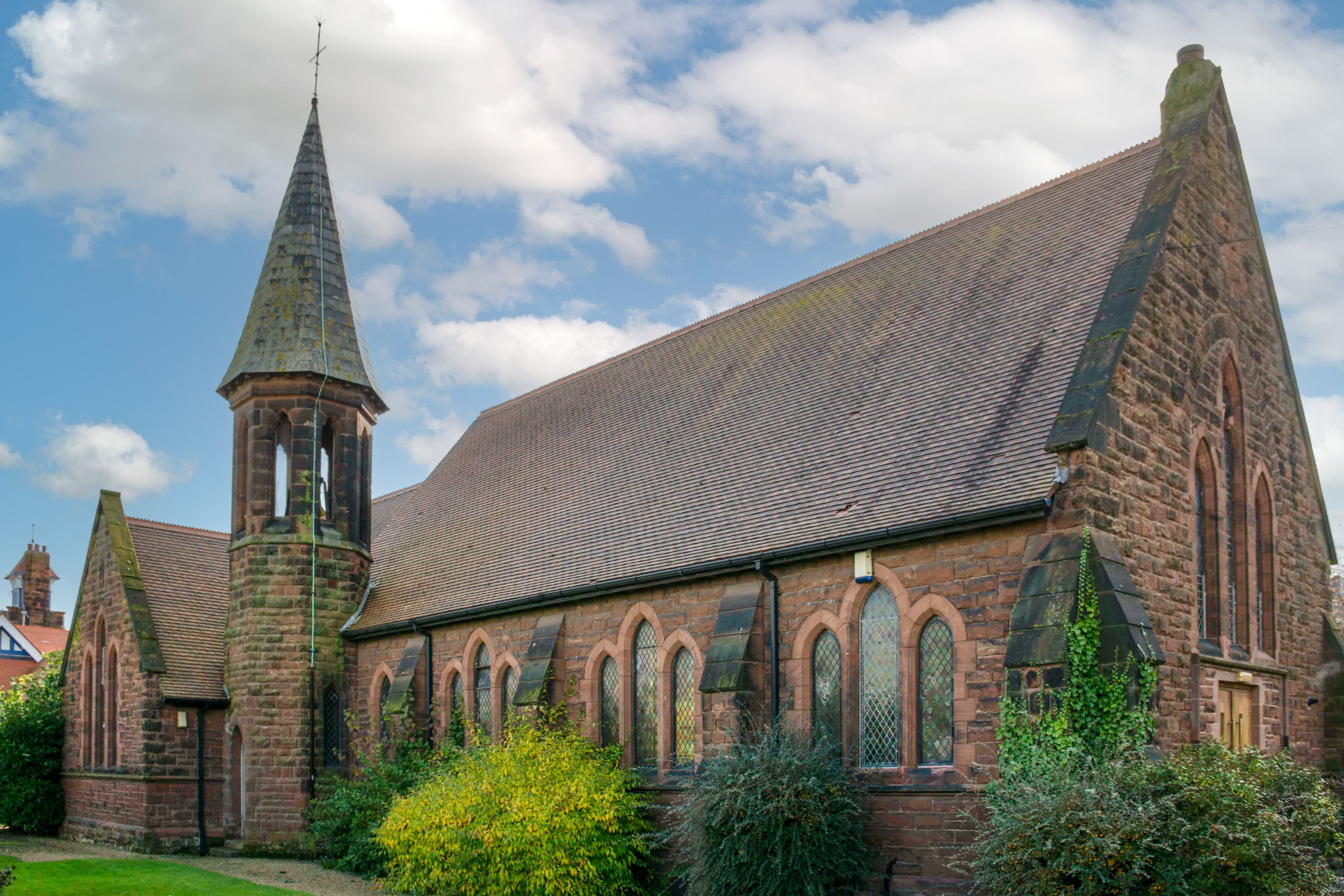 image showing red sandstone church with one spire and Gabel roof
